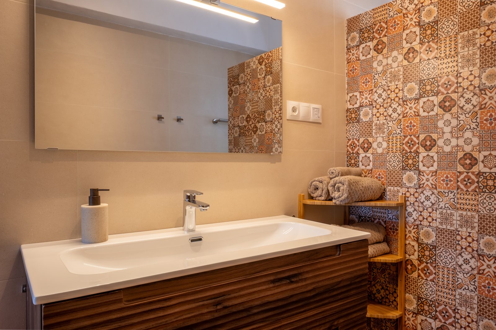 Moderne badkamer met dubbele wastafel en een wand van Andalusische tegels
