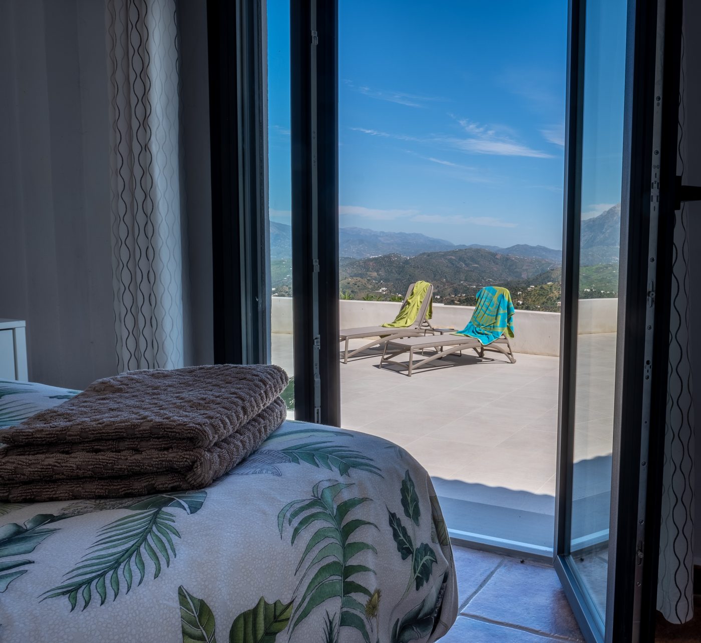 Openslaande deuren van de master bedroom, met direct zicht op het terras en de vallei